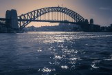 The light across the water acts like a path for the eyes, to a point behind the Sydney Harbour Bridge.